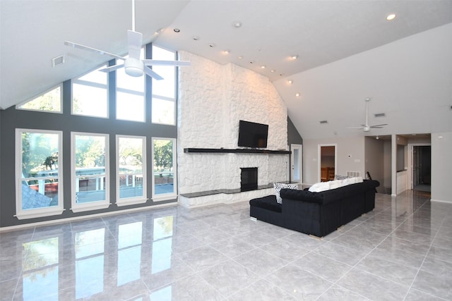 living area featuring visible vents, high vaulted ceiling, a stone fireplace, and a ceiling fan