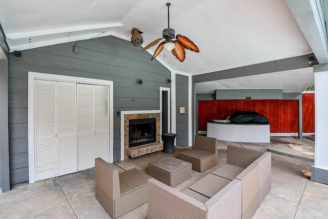 view of patio / terrace with a ceiling fan and an outdoor living space with a fireplace