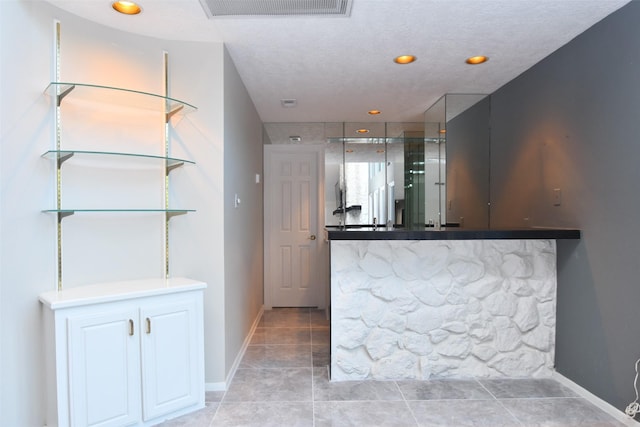 bar with visible vents, a textured ceiling, recessed lighting, light tile patterned flooring, and baseboards