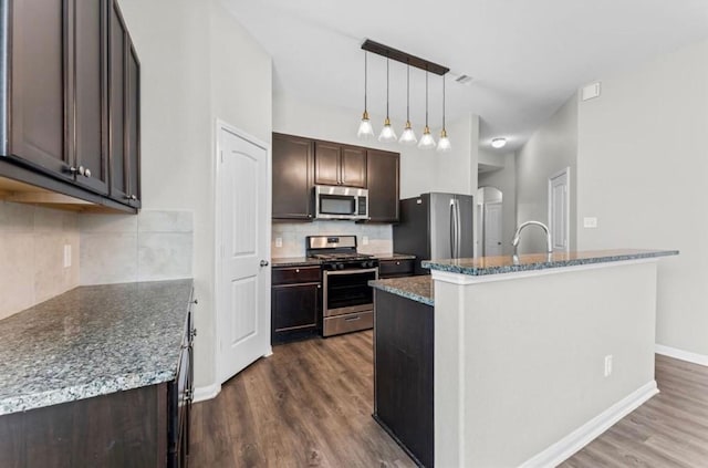 kitchen with dark brown cabinetry, pendant lighting, appliances with stainless steel finishes, dark wood-style floors, and a sink