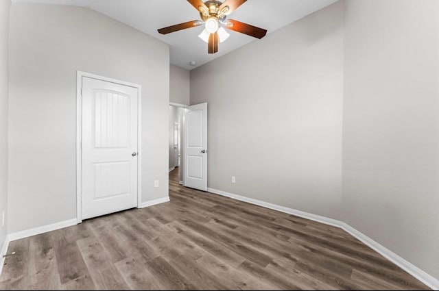 unfurnished bedroom with a ceiling fan, lofted ceiling, baseboards, and wood finished floors