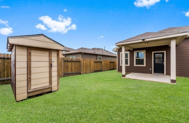 view of yard featuring an outbuilding, a patio area, a storage unit, and a fenced backyard