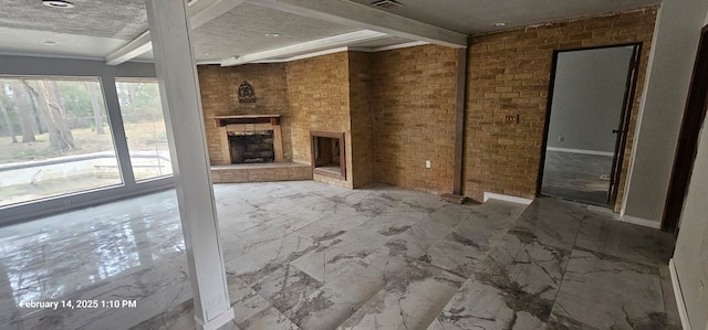 unfurnished living room with beamed ceiling, marble finish floor, brick wall, and a large fireplace