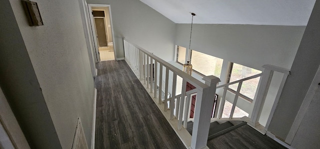 corridor featuring dark wood-style floors, an upstairs landing, and high vaulted ceiling