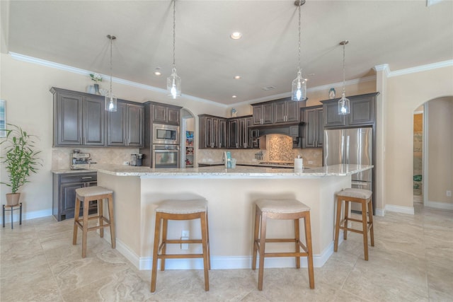 kitchen with stainless steel appliances, arched walkways, custom exhaust hood, and a kitchen breakfast bar