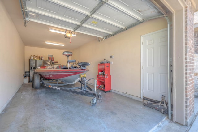 garage featuring a workshop area, a garage door opener, and fridge with ice dispenser