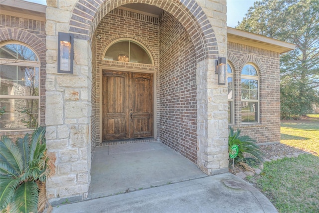 property entrance with stone siding and brick siding