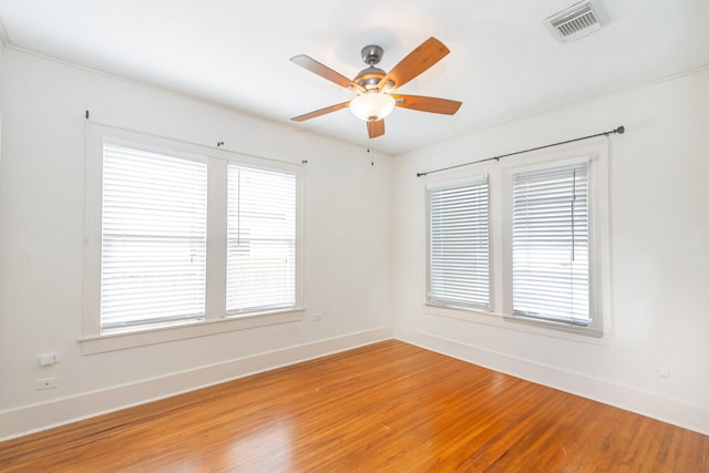 spare room with ceiling fan, visible vents, baseboards, and light wood-style flooring