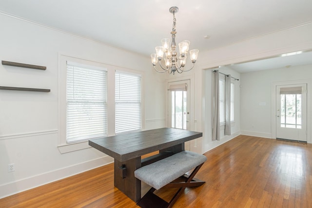 dining space featuring plenty of natural light, baseboards, wood-type flooring, and ornamental molding