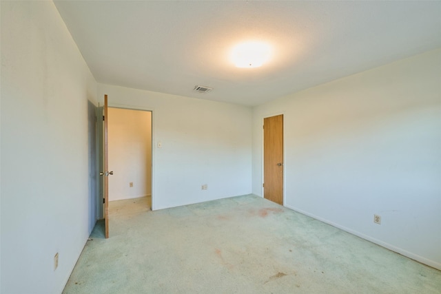 unfurnished bedroom featuring light carpet and visible vents