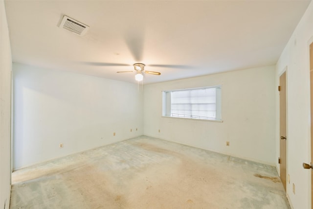 empty room featuring visible vents, light colored carpet, and a ceiling fan