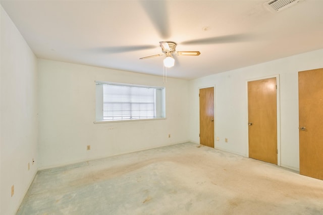 unfurnished bedroom with visible vents, two closets, and ceiling fan