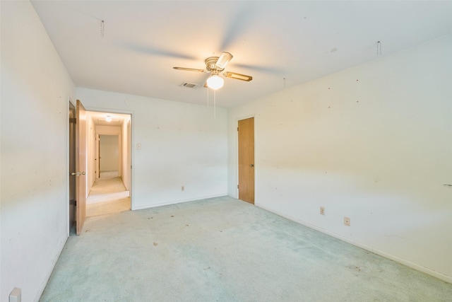 unfurnished bedroom featuring visible vents, baseboards, light colored carpet, and ceiling fan