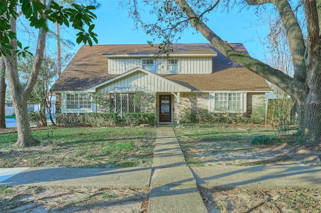 view of front of home featuring stone siding, board and batten siding, and a shingled roof