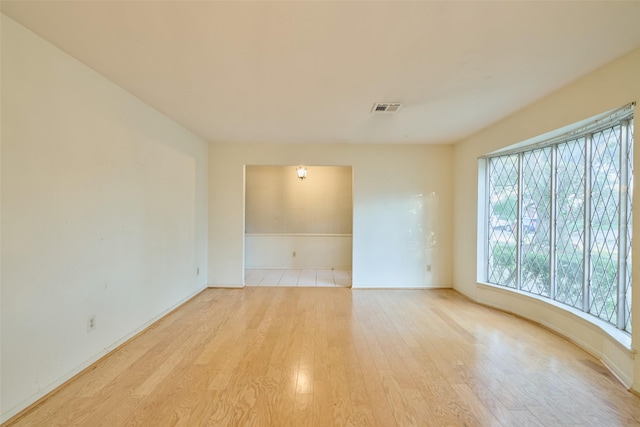 unfurnished room featuring light wood-type flooring and visible vents