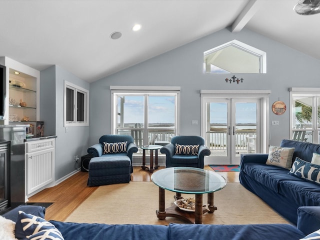 living area featuring lofted ceiling with beams, french doors, baseboards, and light wood-style flooring