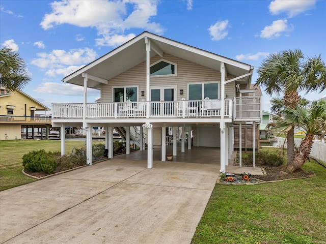 view of front of house with a front lawn, stairs, covered porch, a carport, and driveway