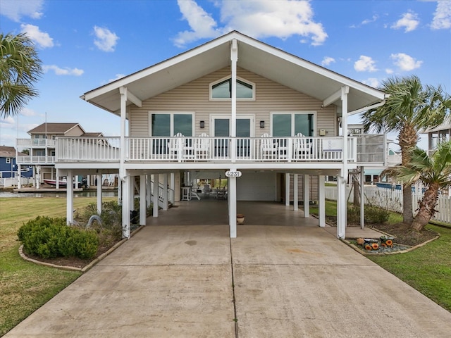 coastal inspired home with a carport, a front yard, and driveway