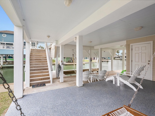 view of patio with stairs and a water view