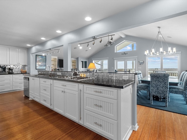 kitchen featuring light wood-type flooring, a sink, dark countertops, white cabinetry, and appliances with stainless steel finishes