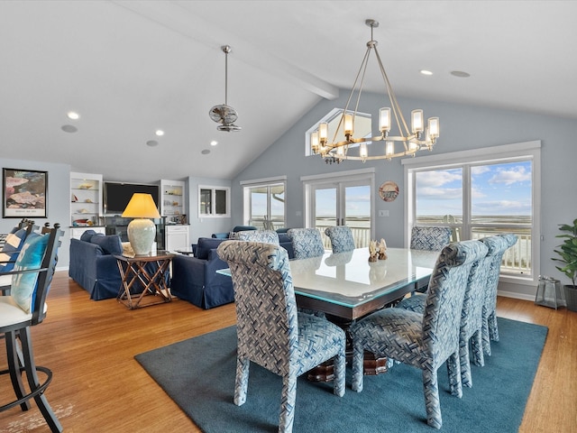 dining area featuring an inviting chandelier, lofted ceiling with beams, wood finished floors, and a healthy amount of sunlight