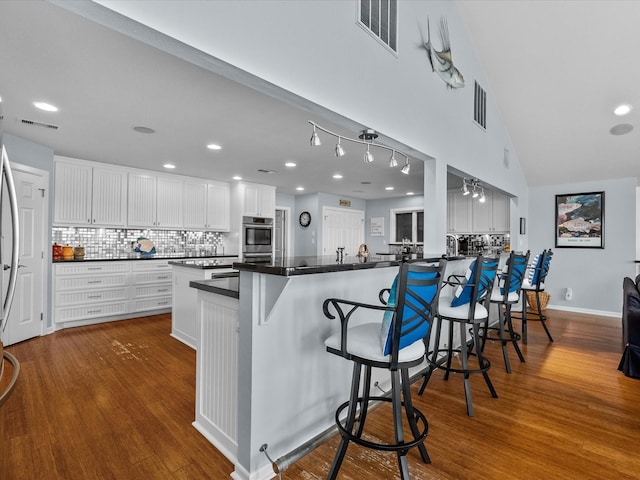 kitchen with dark countertops, a peninsula, and visible vents