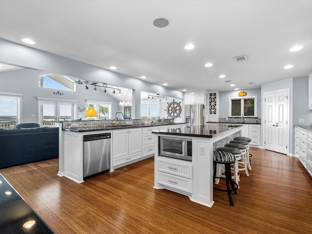 kitchen with dark countertops, visible vents, white cabinetry, and stainless steel appliances