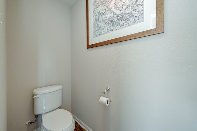 bathroom featuring toilet and baseboards