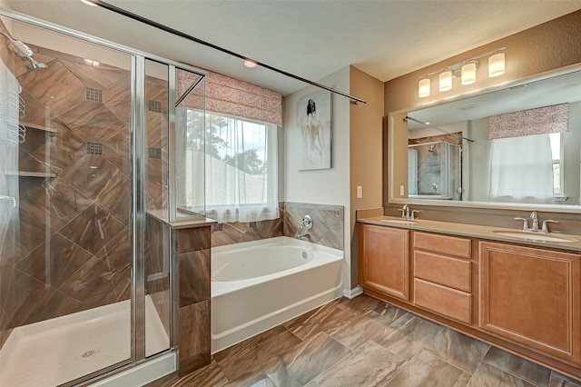 bathroom with double vanity, a bath, a stall shower, and a sink