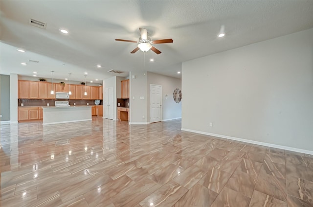 unfurnished living room featuring visible vents, recessed lighting, baseboards, and a ceiling fan