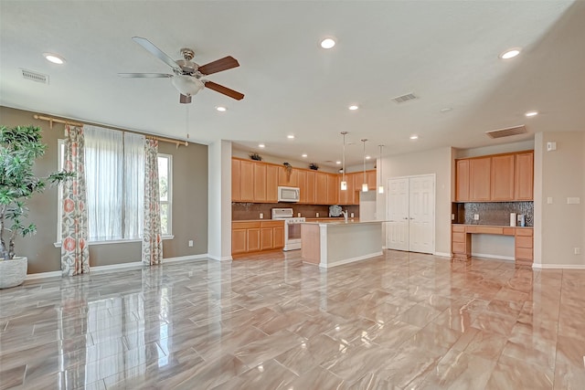 kitchen with stainless steel microwave, open floor plan, white gas stove, and visible vents