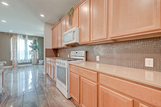 kitchen featuring white appliances, light countertops, tasteful backsplash, and light brown cabinetry