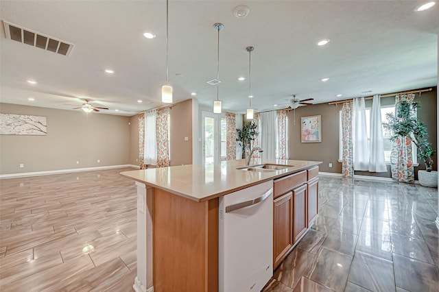 kitchen with visible vents, a center island with sink, a sink, open floor plan, and dishwasher