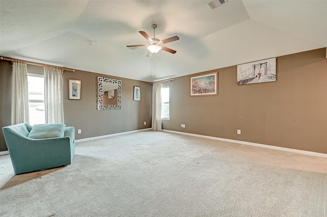 living area featuring carpet, visible vents, baseboards, lofted ceiling, and ceiling fan