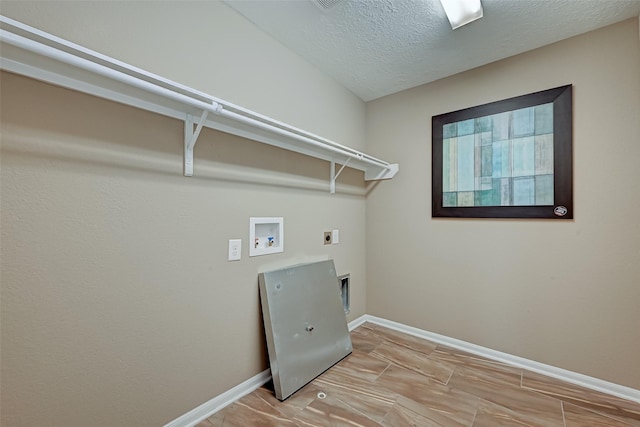 washroom featuring baseboards, washer hookup, laundry area, electric dryer hookup, and a textured ceiling