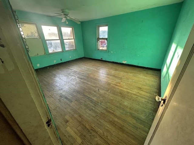 unfurnished room featuring ceiling fan, baseboards, and hardwood / wood-style floors