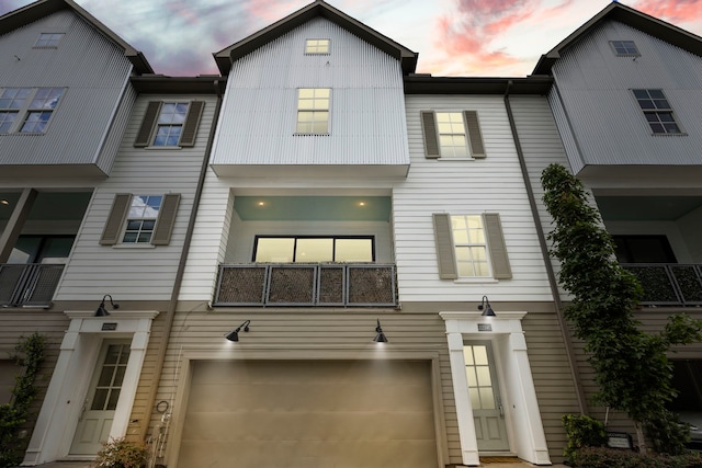 view of property featuring a balcony and a garage