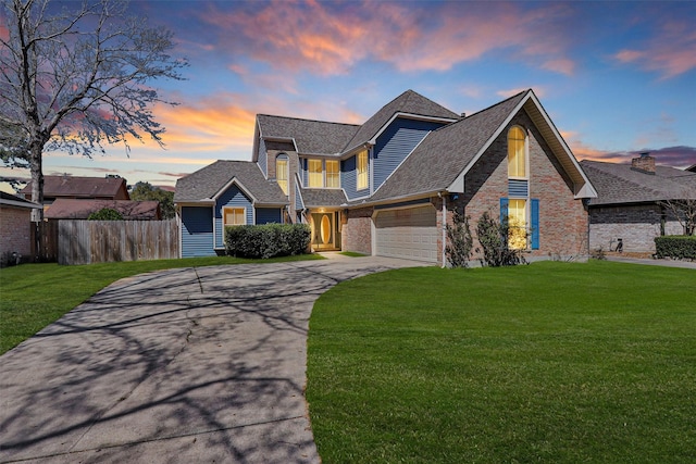 view of front of house with a front lawn, concrete driveway, fence, and a garage