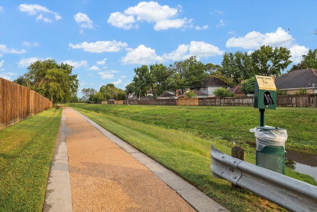 view of home's community featuring a yard and fence