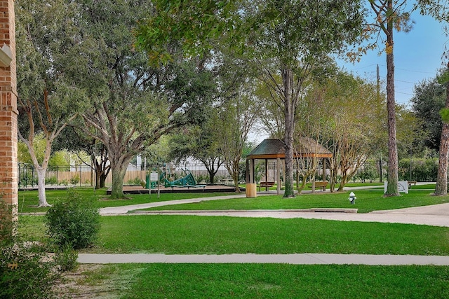 view of home's community featuring a gazebo, playground community, a lawn, and fence