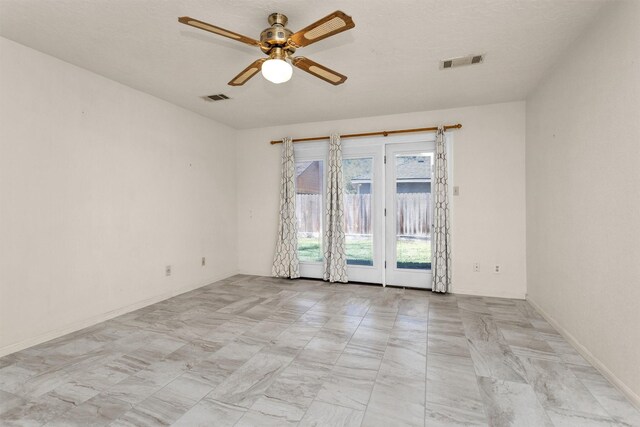 empty room featuring visible vents, baseboards, and a ceiling fan