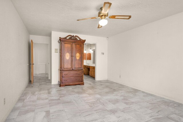 unfurnished bedroom featuring ceiling fan, connected bathroom, and a textured ceiling