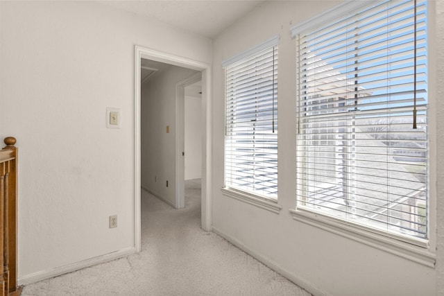 corridor with carpet and baseboards