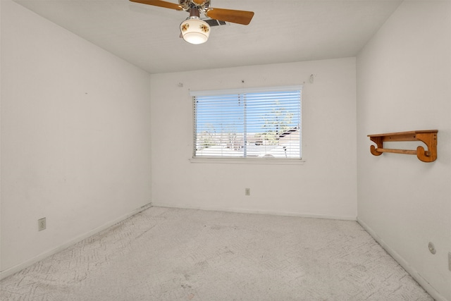 carpeted spare room featuring a ceiling fan and baseboards