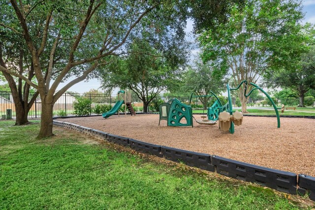 community play area featuring a lawn and fence