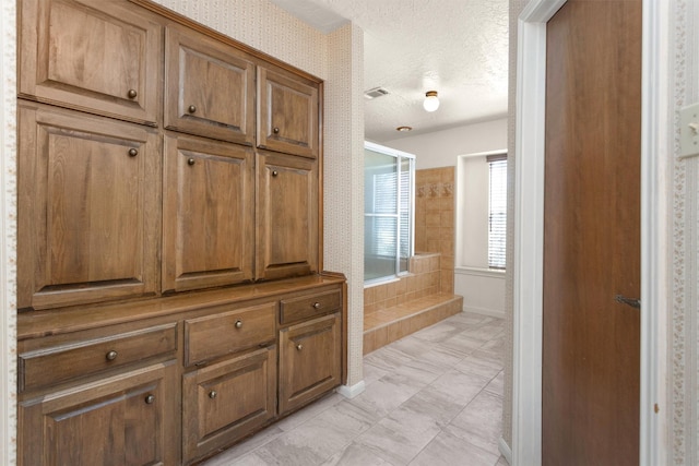 bathroom with visible vents, baseboards, and a textured ceiling