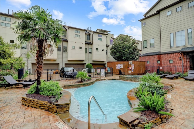 pool with a patio and fence