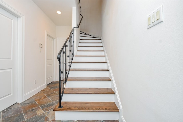 staircase featuring stone tile floors, recessed lighting, and baseboards