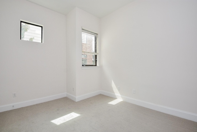 empty room with baseboards and light carpet