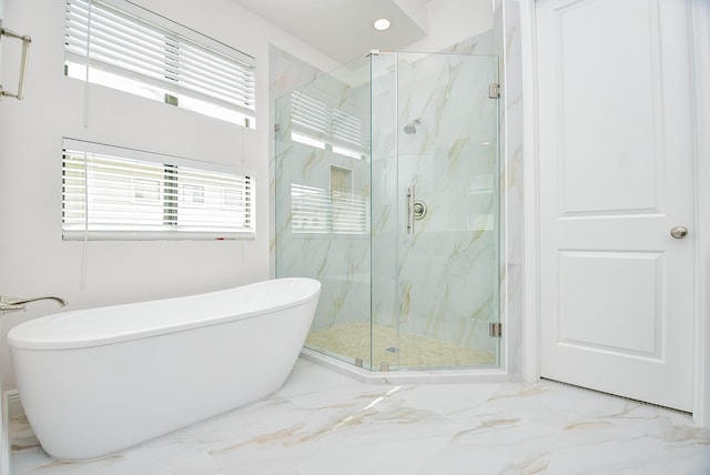 bathroom with a marble finish shower, marble finish floor, and a freestanding tub